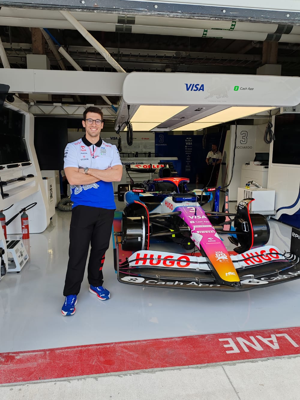Matteo Tomei nel garage della squadra, davanti alla monoposto numero 3 sollevata sui cavalletti.